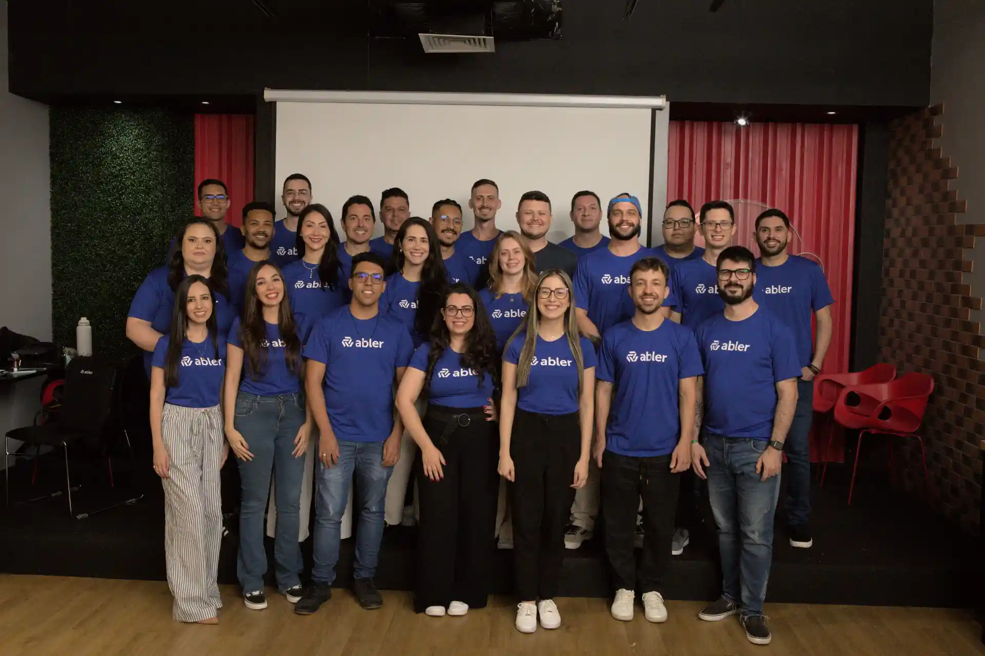 Equipe unida vestindo camisetas da marca abler, destacando a importância de uma marca empregadora forte para atrair e reter talentos no mercado.