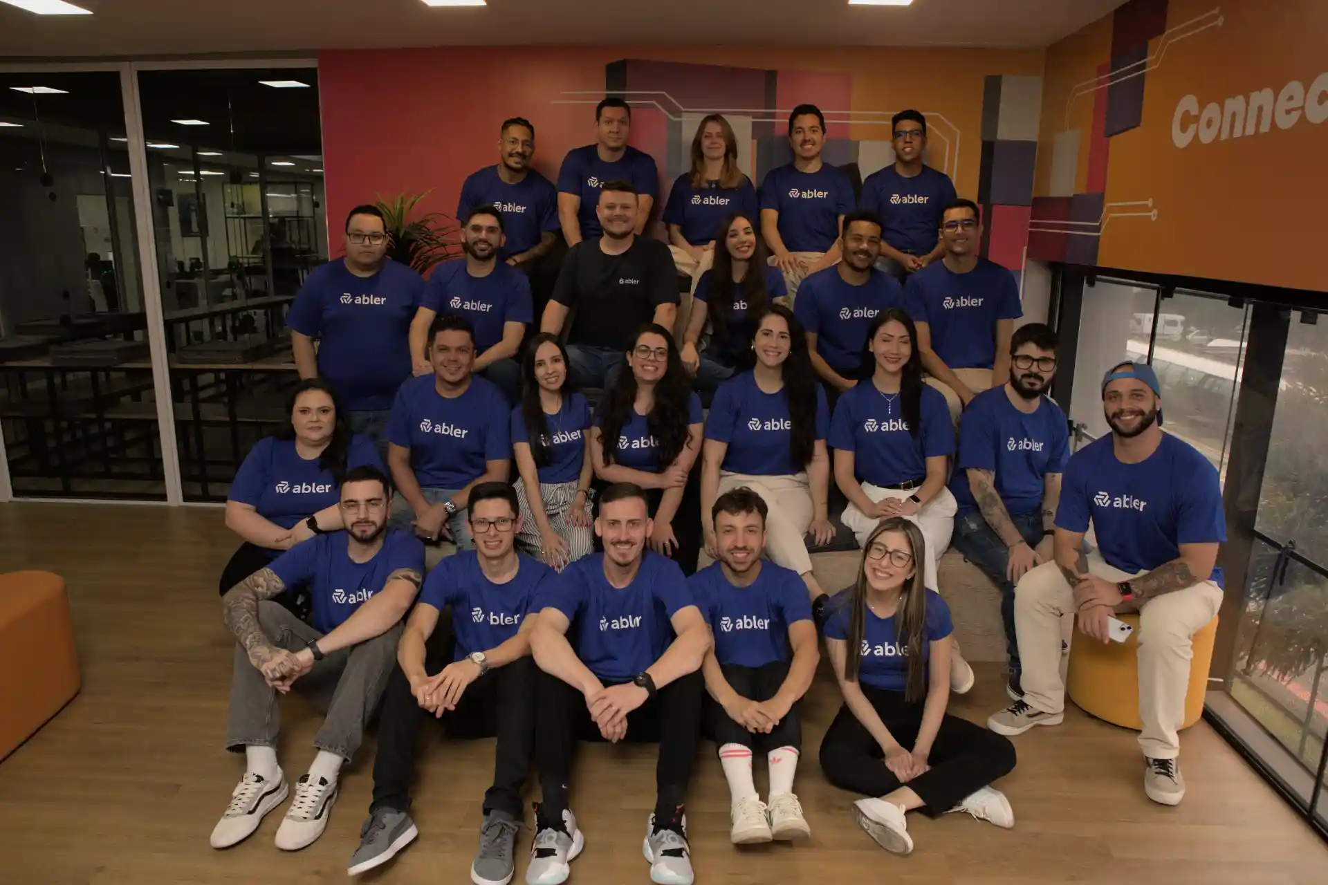 Grupo diversificado de colaboradores da empresa Abler, promovendo políticas inclusivas em um ambiente de trabalho acolhedor e colaborativo.