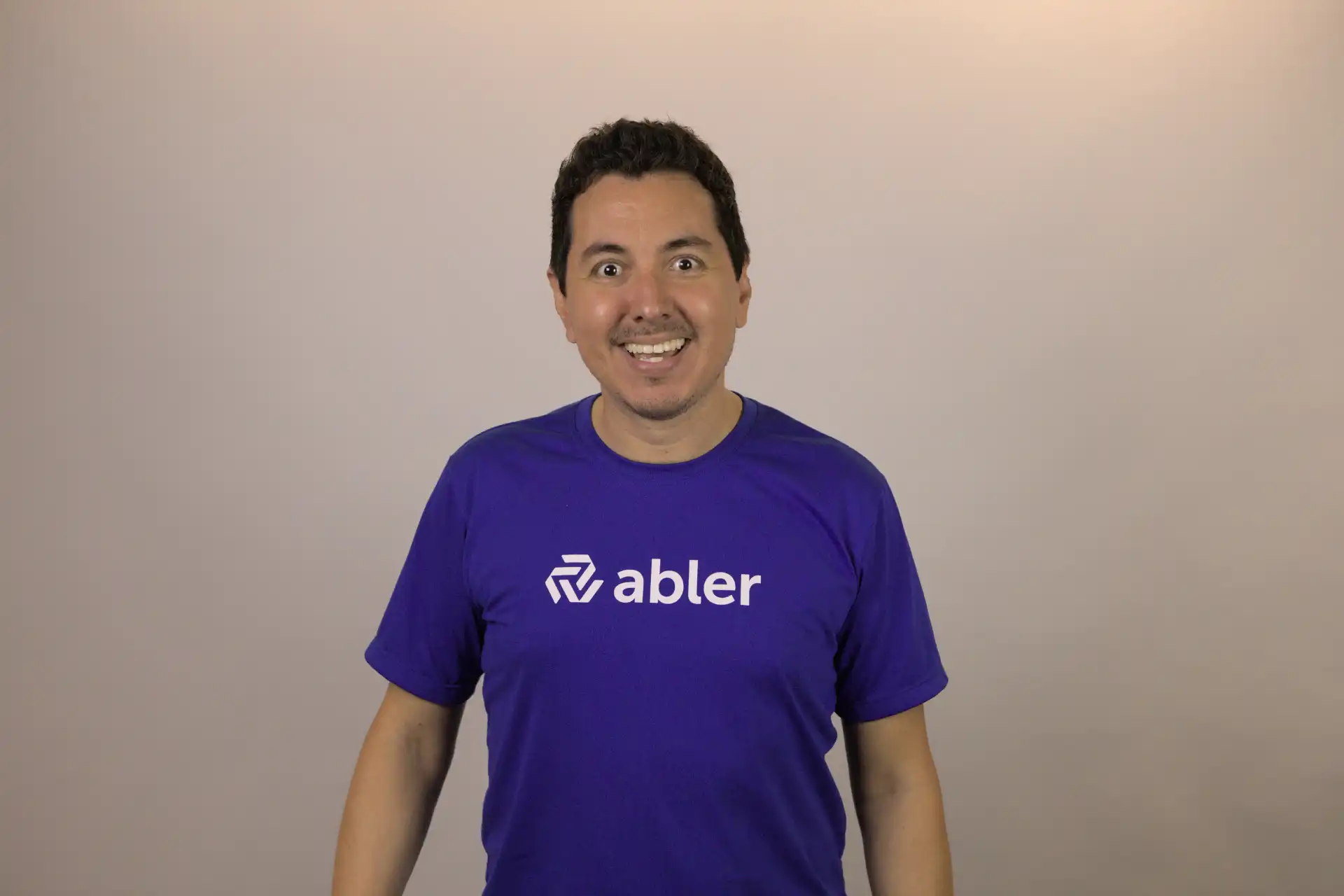 Homem sorridente usando camiseta da abler, representando a importância de candidatos qualificados no mercado de trabalho.