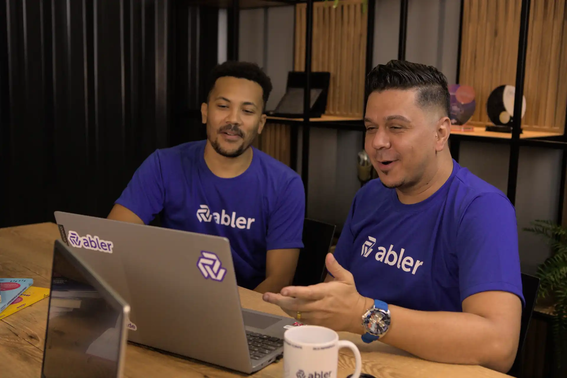 Imagem de profissionais discutindo estratégias de recrutamento e seleção executiva em um ambiente de escritório moderno, com computador e equipamentos.