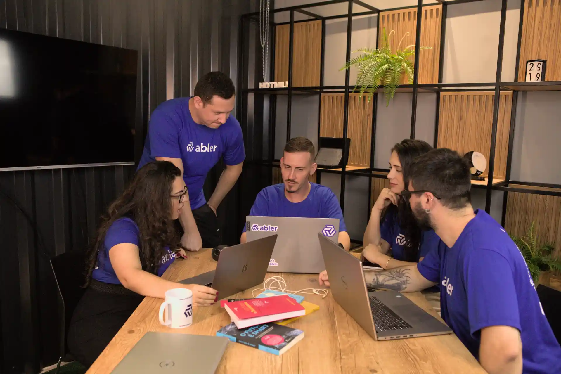 Imagem de uma equipe colaborando em um ambiente moderno, discutindo estratégias de recrutamento inclusivo com foco na diversidade e inclusão.