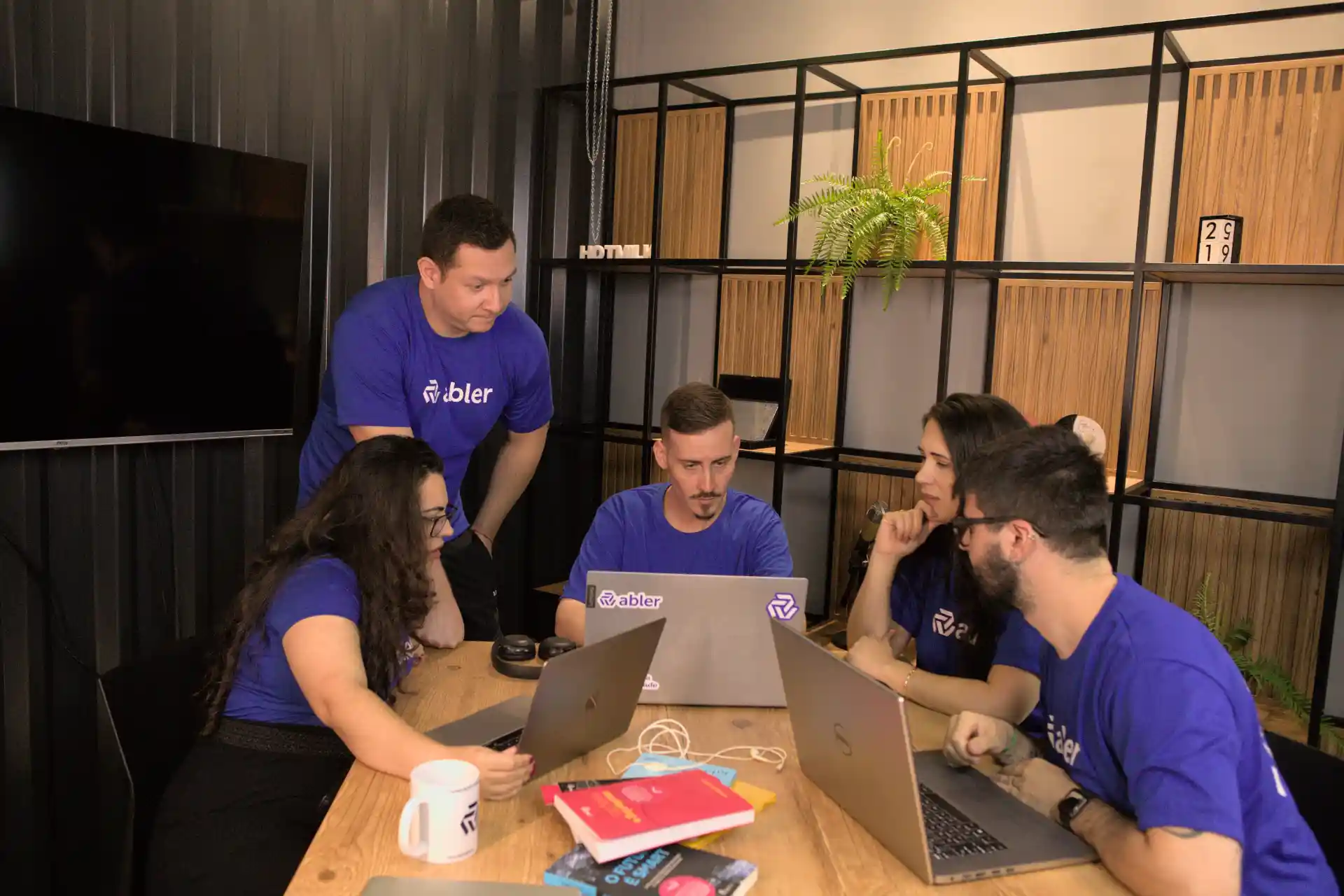 Grupo de profissionais colaborando em um projeto, analisando estratégias para encontrar os candidatos certos em um ambiente de trabalho moderno.