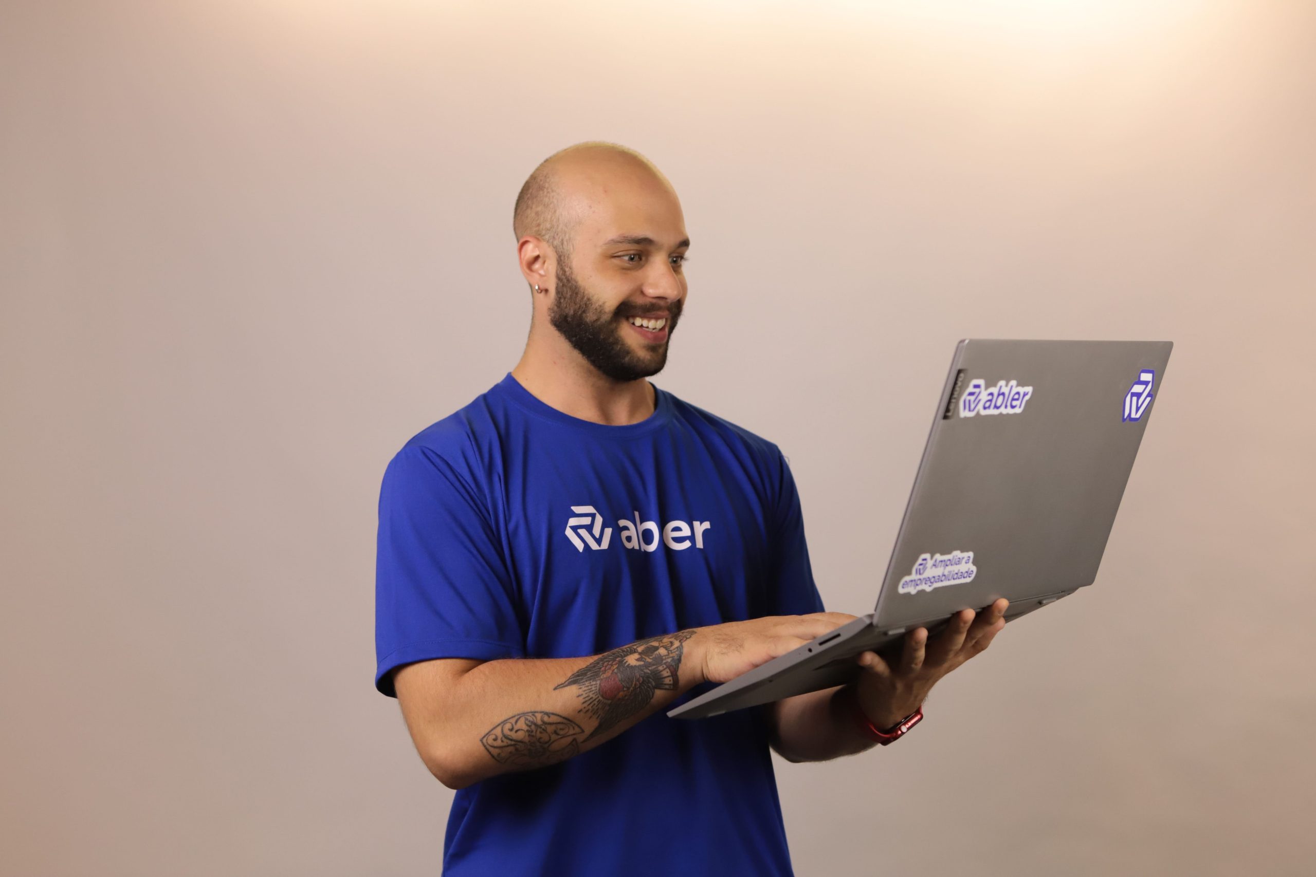 Profissional da abler utilizando notebook em pé durante uma atividade estratégica de Recrutamento Ativo, representando uma abordagem mais proativa, dinâmica e orientada à busca de talentos fora dos processos tradicionais de recrutamento.